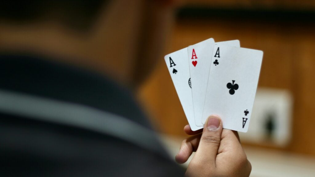 Image of a man holding three cards